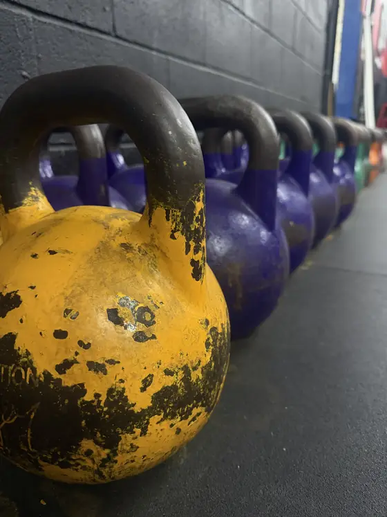 Kettlebells lined up along the wall at Legacy Gym